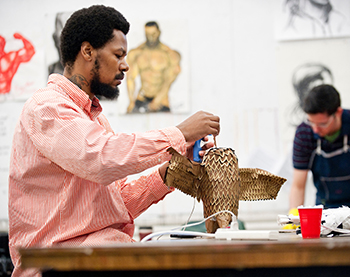 An undergraduate student works on a three-dimensional mixed-media drawing in class, Art tile