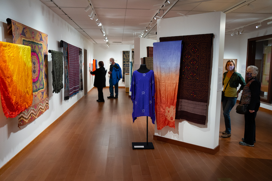 interior gallery space with brightly colored textiles on display